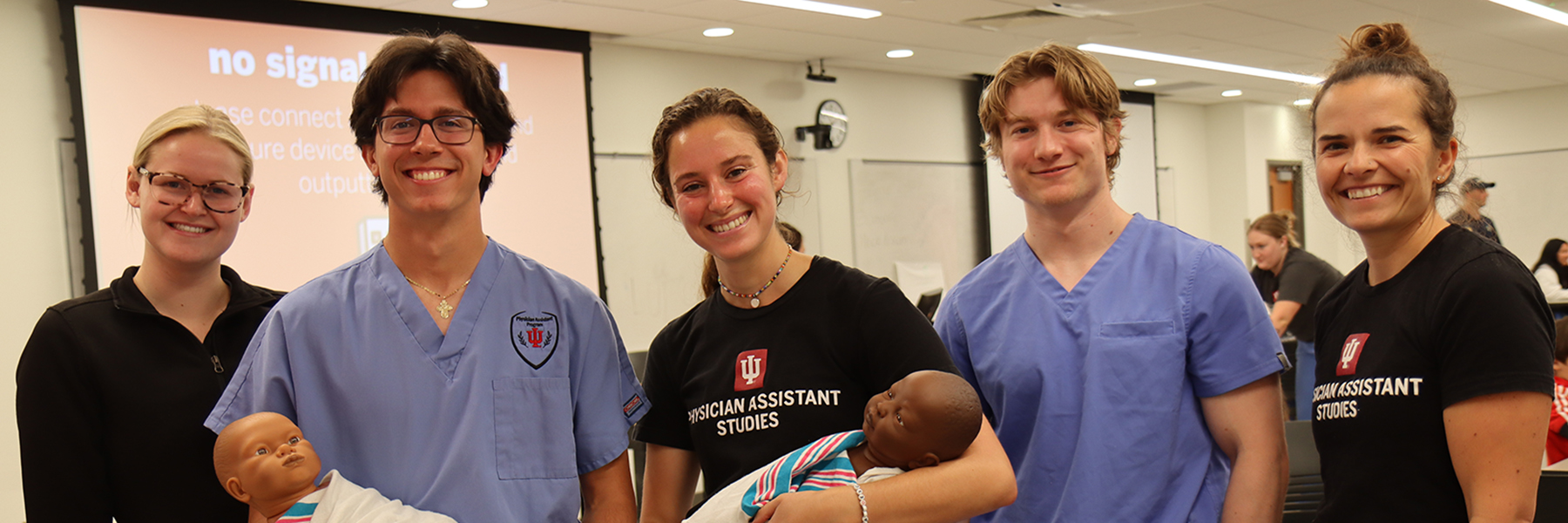 5 PA students posing with simulation babies
